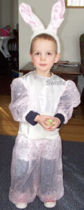 little boy wearing pink sparkly jumpsuit and rabbit ears