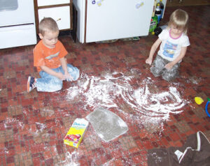 Two toddlers in a huge mess of powdered sugar everywhere