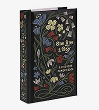 black hardcover diary with "One Line a Day" written on the cover, surrounded by flowers in blue, yellow, white, and red